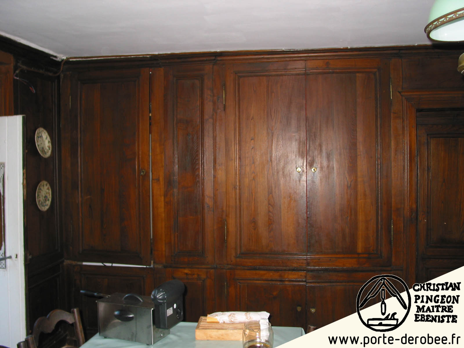 Boiseries forme de portes drobe dans une maison de campagne masquant une cuisine